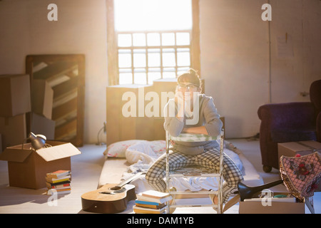 Woman unpacking boxes in attic Stock Photo