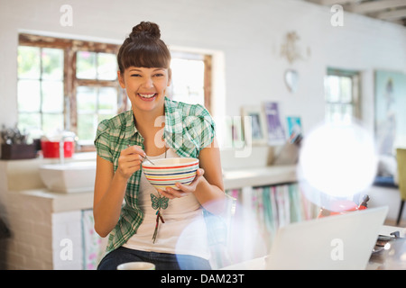 Woman eating in kitchen Stock Photo