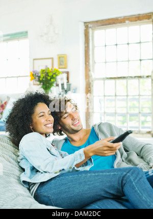 Couple watching television in beanbag chair Stock Photo
