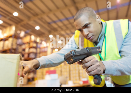 Worker scanning boxes in warehouse Stock Photo