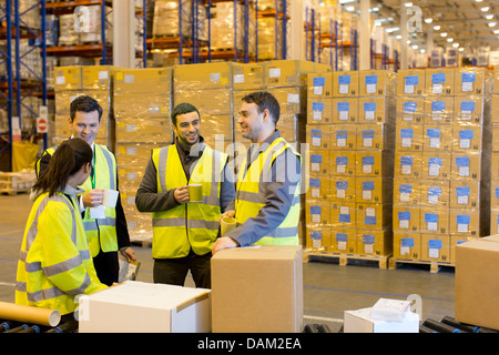 Workers drinking coffee in warehouse Stock Photo