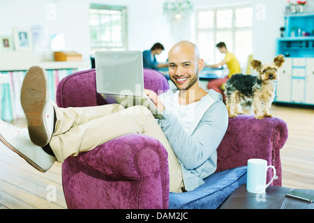 Man using laptop in armchair Stock Photo