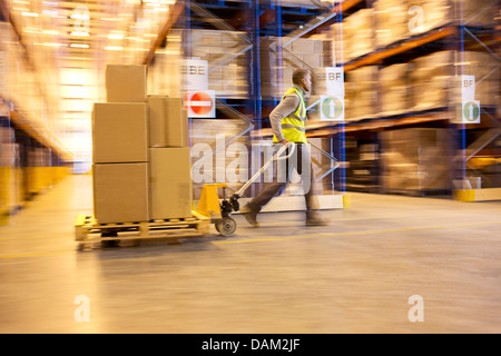 Blurred view of worker carting boxes in warehouse Stock Photo