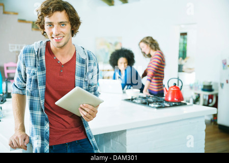 Man using tablet computer in kitchen Stock Photo