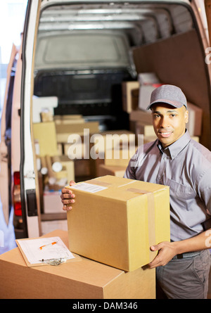 Delivery boy loading boxes into van Stock Photo