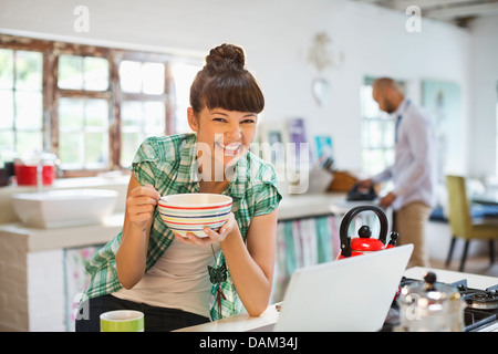 Woman using laptop at breakfast Stock Photo