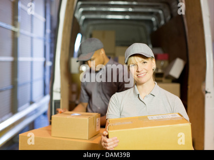 Delivery people loading boxes into van Stock Photo