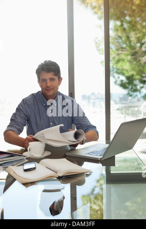 Back view of businessman working with laptop in modern office interior ...