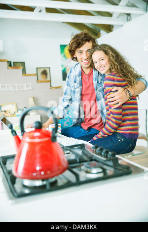 Couple hugging in kitchen Stock Photo
