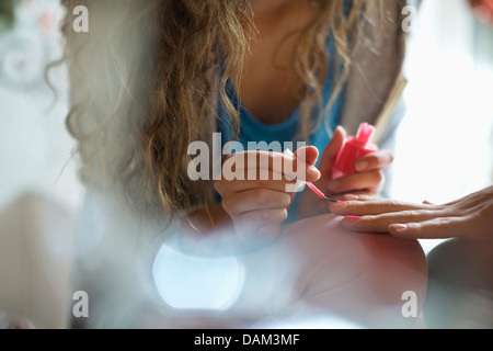 Woman painting friend's nails Stock Photo