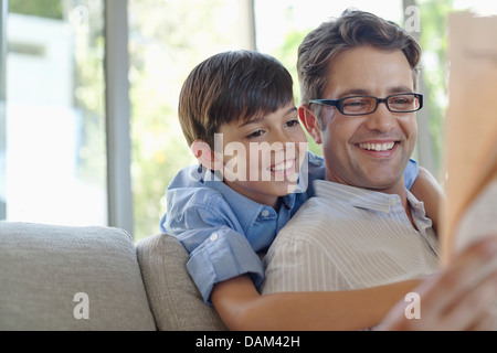Father and son hugging on sofa Stock Photo