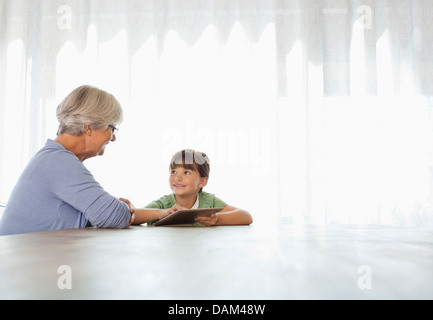 Older woman and granddaughter using tablet computer Stock Photo