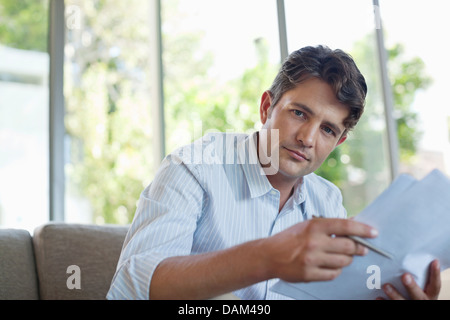 Businessman reading papers on sofa Stock Photo