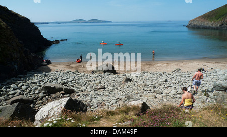 People with kayaks kayaking and walking on the beach at Porth Meigan near Whitesands Bay, St. David's Head, Pembrokeshire, Wales, UK Stock Photo