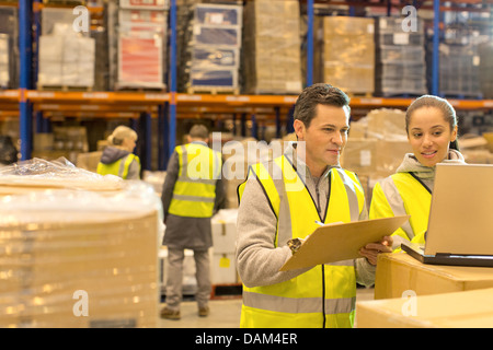 Workers using laptop in warehouse Stock Photo