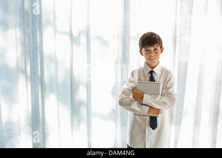 Boy in shirt and tie holding tablet computer Stock Photo