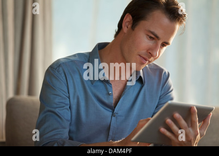 Businessman using tablet computer on sofa Stock Photo