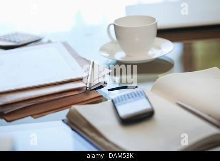 Notebook, cell phone and cup of coffee on desk Stock Photo