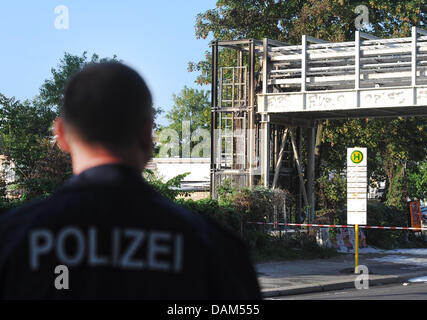 A police officer stands in front of the cable bridge, where the fire broke out at Ostkreuz station in Berlin, germany, 23 May 2011. Because of the cable fires train transportation broke down and many people waited in vain for the city and regional trains. Photo: Britta Pedersen Stock Photo