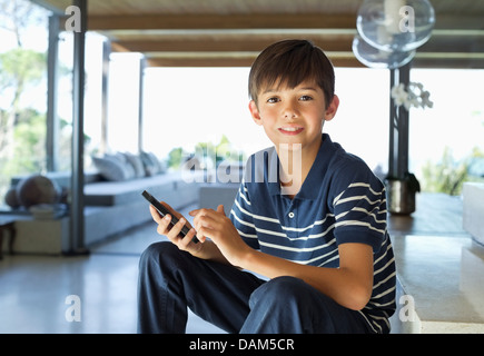 Boy using cell phone on steps Stock Photo