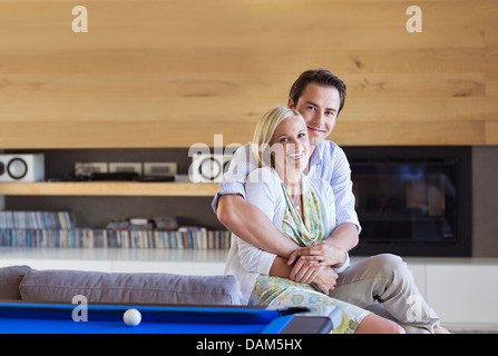 Couple hugging on sofa in living room Stock Photo