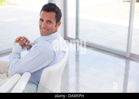 Businessman smiling in office chair Stock Photo