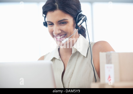 Businesswoman wearing headset at desk Stock Photo