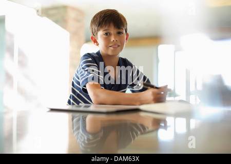 Boy doing homework at counter Stock Photo