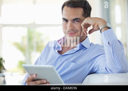 Businessman using tablet computer on sofa Stock Photo