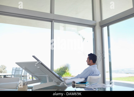 Businessman looking out office window Stock Photo