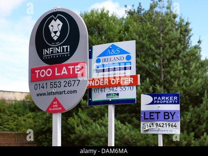 For sale signs one with 'too late' on it rather than sold or under offer Stock Photo
