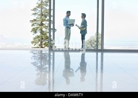 Businessmen talking in office Stock Photo