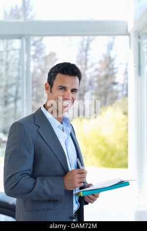 Businessman reading papers in office Stock Photo