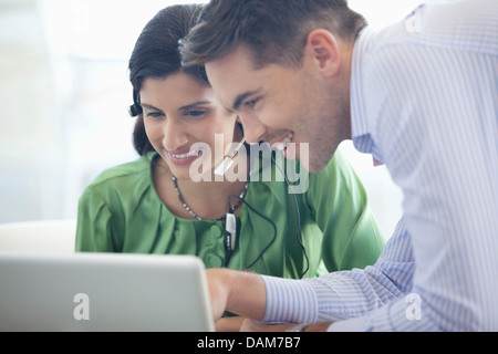 Business people using laptop together in office Stock Photo