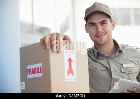 Delivery boy carrying ‘fragile’ package Stock Photo