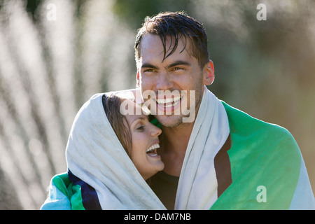 Couple wrapped in towel outdoors Stock Photo