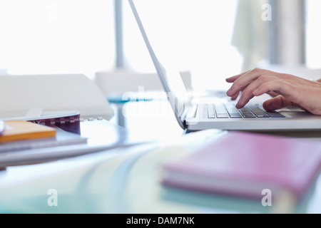 Businesswoman using laptop at desk Stock Photo