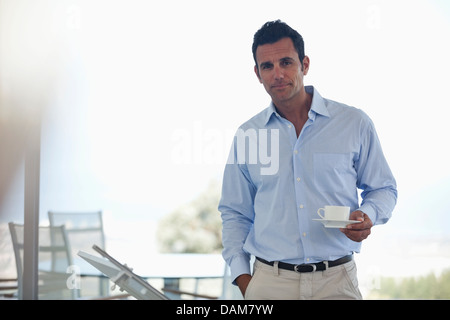 Businessman having cup of coffee in office Stock Photo