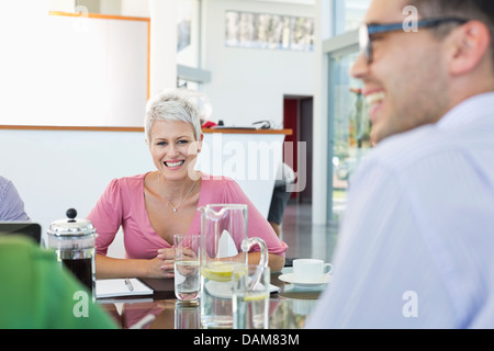 Business people smiling in meeting Stock Photo