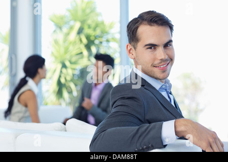 Businessman smiling on sofa in office Stock Photo