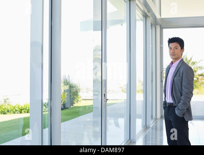 Businessman standing at office window Stock Photo