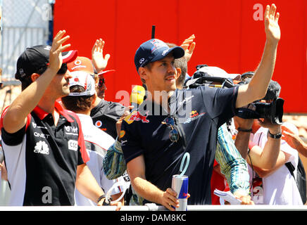 German Formula One driver Sebastian Vettel (C) of Red Bull and German driver Timo Glock of Virgin (L) greet spectators during the drivers' parade before the start at the street circuit of Monte Carlo, Monaco, 28 May 2011. The Formula 1 Grand Prix of Monaco is the sixth of 19 season races. Photo: Jens Buettner Stock Photo