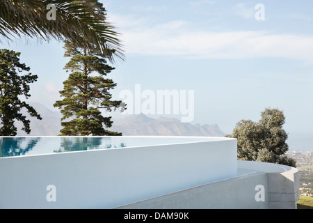 Infinity pool overlooking trees and hillside Stock Photo
