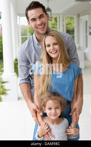 Family smiling together on porch Stock Photo