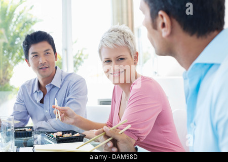 Business people eating sushi in office Stock Photo