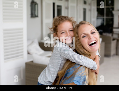 Mother and daughter playing on porch Stock Photo