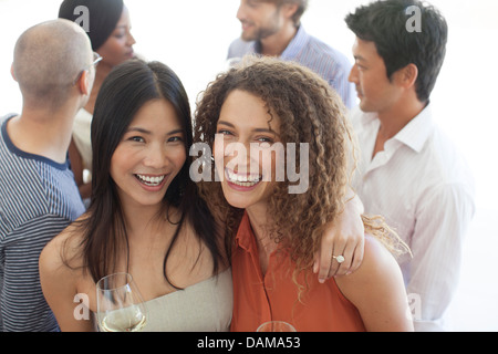Women smiling together at party Stock Photo