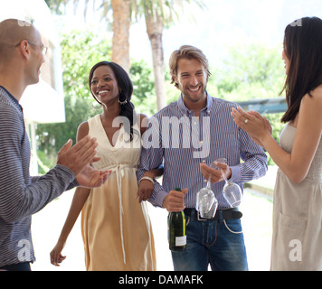 Friends cheering smiling couple Stock Photo