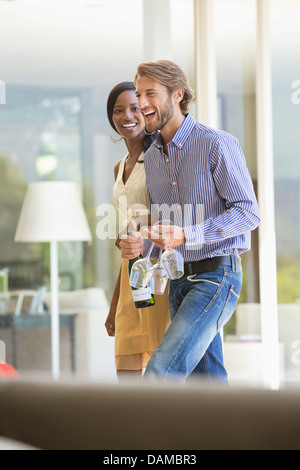 Couple carrying wine bottle and glasses Stock Photo