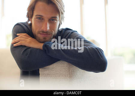 Man leaning on arm of sofa Stock Photo